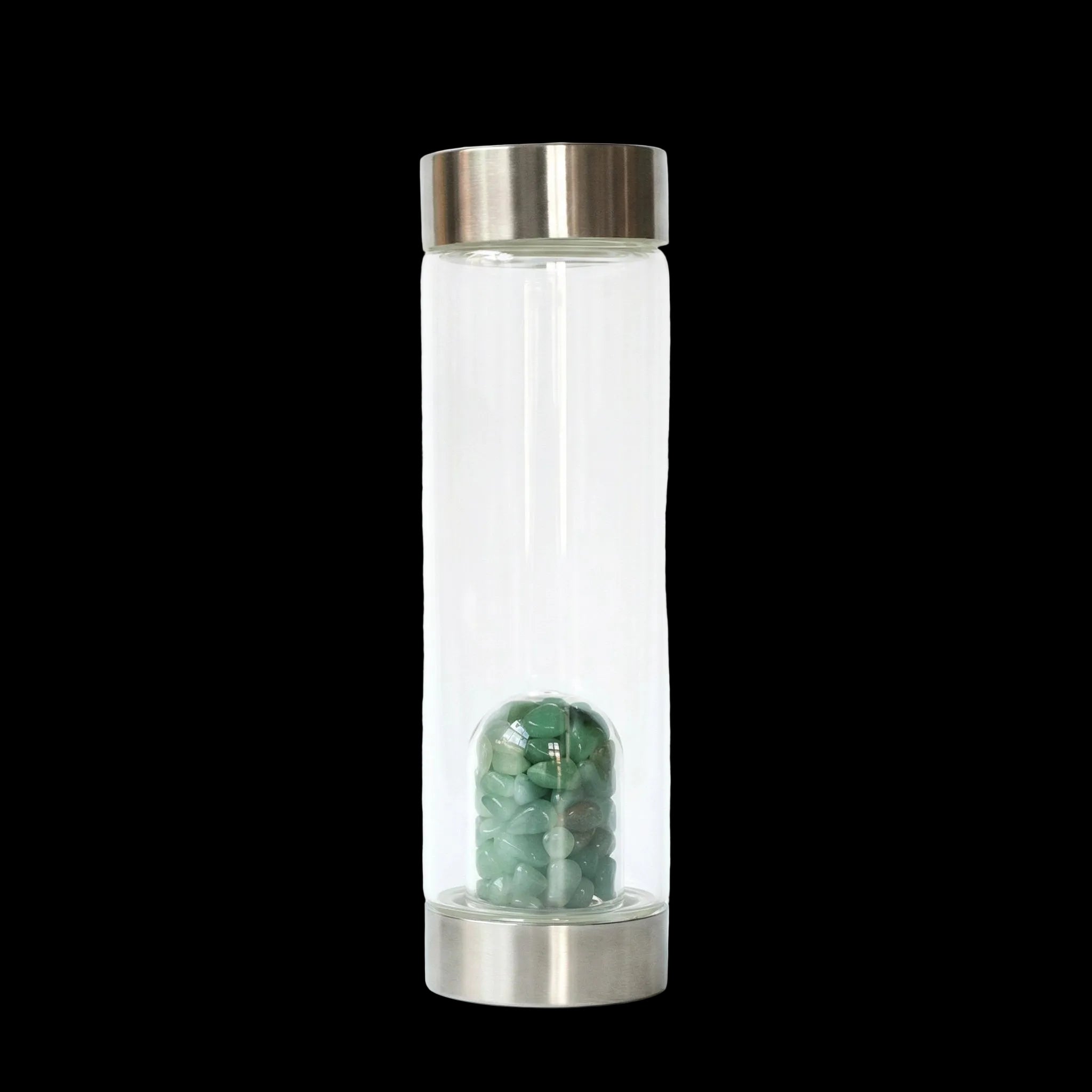 Clear glass bottle with metal cap and base containing green stones on a white background