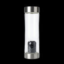 Clear glass bottle with metal cap and interior filter on a white background